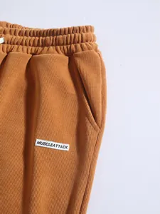 Gros plan d'un pantalon en velours côtelé orange pour homme avec texture et poche