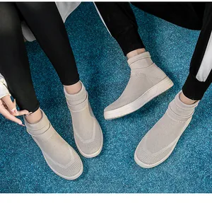 Detailansicht atmungsaktiver beiger Strick-Sneaker, getragen von einem Paar im Freien.
