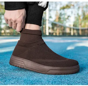 Nahaufnahme brauner atmungsaktiver Fly-Knit-Socken-Sneaker auf blauem Sportplatz.