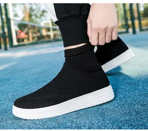 Nahaufnahme von atmungsaktiven schwarzen Fly-knit-Sneakern mit weißer Sohle auf dem Platz