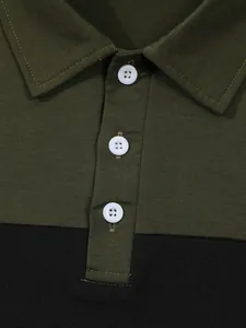 Detailed view of olive green and black color-block polo shirt collar with white buttons