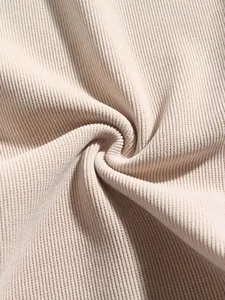 Gros plan macro d'un tissu en velours côtelé beige montrant de fines côtes verticales