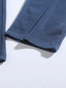 Détail macro de l'ourlet d'un pantalon en velours côtelé bleu avec texture côtelée