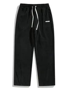 Détail du pantalon en velours côtelé noir pour homme avec cordon blanc et coupe droite