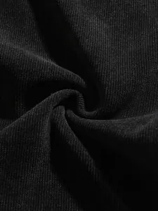 Gros plan détaillé sur la texture du tissu en velours côtelé noir pour pantalons rétro.