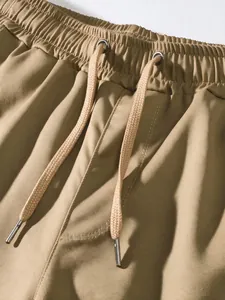 Close-up detail of men's khaki cargo pants featuring elastic waist and adjustable drawstring.