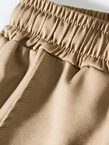 Close-up of khaki cargo pants with elastic waistband and twill fabric stitching detail.