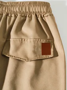 Detailed close-up of khaki cargo pants featuring elastic waistband and back pocket flap.