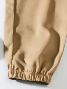 Macro detail of men's khaki cargo pants featuring elasticated cuffs and twill weave texture