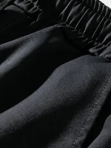 Close-up of black elastic waistband and durable twill fabric texture on these cargo pants.