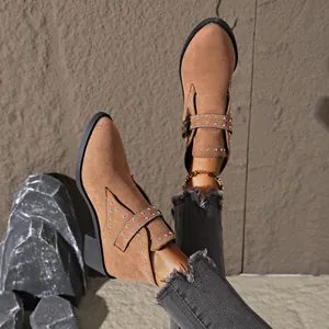 Primer plano de botines de punta camel con remaches plateados y tacón medio muy elegante.