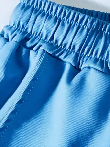 Close-up detail of elastic waistband and stitching on blue men's casual cargo pants.