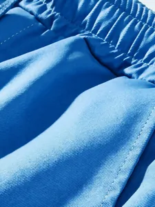Close-up view showing the blue twill fabric and elastic waistband of men's cargo pants.