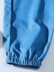 Close-up of the elasticated hem on blue cargo pants showing fine stitching and twill fabric