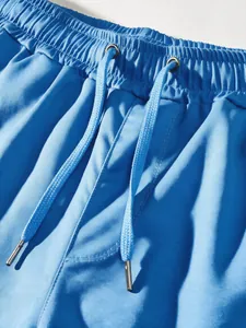 Detailed macro shot showing the adjustable drawstring waistband of men's blue cargo pants