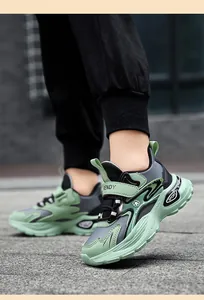 Vista lateral de zapatillas infantiles verdes y grises con suelas gruesas y correas
