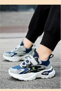 Vista lateral de elegantes zapatillas azules y grises para niños con suelas blancas