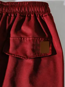Close-up of men's red cargo pants showing elastic waistband and back pocket flap detail