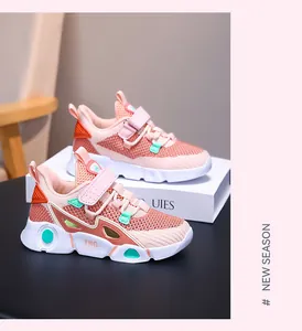Detailed side view of pink mesh breathable girls' sneakers with orange accents