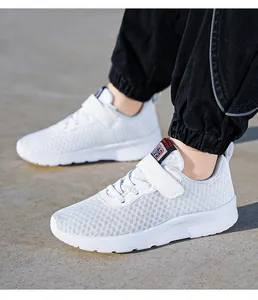 Close-up of breathable white mesh kids running shoes with Velcro strap in a lifestyle shot