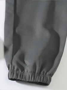 Close-up detail of grey cargo pants featuring elasticated jogger cuffs and twill fabric