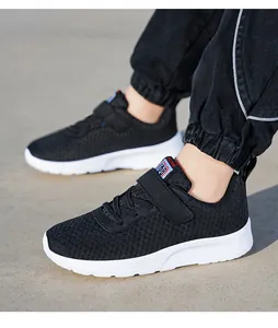 Black breathable mesh children's sneakers with soft white soles and hook-and-loop closure