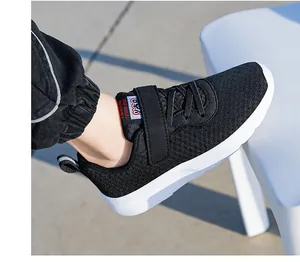 Detail shot of black breathable mesh children's running shoes with secure velcro strap.