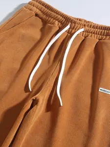 Detailed view of brown corduroy trousers waist with white drawstring and ribbed texture