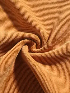 Macro detail of high-quality orange corduroy fabric for men's vintage straight pants