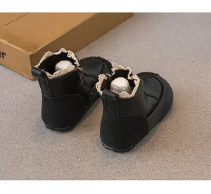 Detail view of black girl's boots with delicate lace trim and side zipper closure