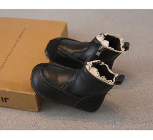 Detail shot of black girls' Martin boots with delicate lace trim and warm fleece lining