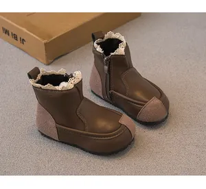 Macro view of brown leather children's boots featuring delicate lace trim and side zipper