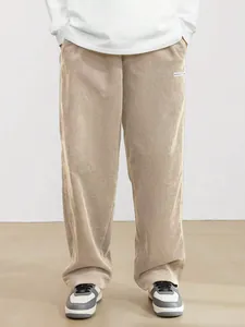 Detail of men's beige corduroy straight-leg pants showing texture and vintage street style.