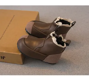 Close-up detail of brown girl's boots featuring delicate lace trim and side zipper closure