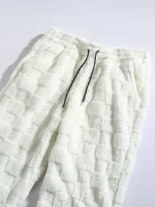Detail view of white checkered plush trousers featuring soft fuzzy texture and black drawstring