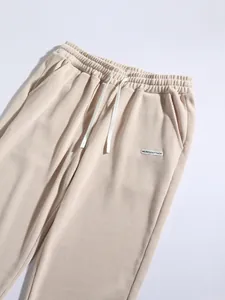Detail of beige corduroy fabric texture and elastic drawstring waist on men's casual pants