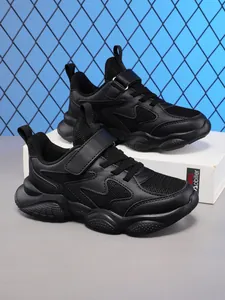 Detailed side view of black kids breathable running shoes with velcro and soft soles