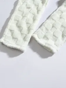 Detailed macro shot of white plush checkerboard texture on winter lounge pants for men
