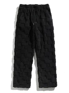 Macro view of men's black checkerboard plush trousers with unique textured fleece pattern.