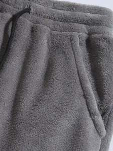 Detail van grijze koraalvlies joggingbroek met elastische tailleband en zak