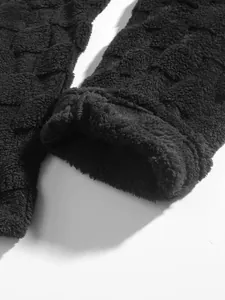Close-up of black fleece trousers with textured square grid pattern for winter warmth