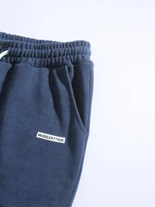 Detail of blue corduroy pants featuring an elastic drawstring waist and woven brand label.