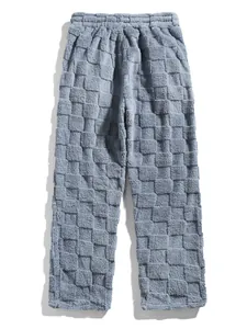 Detail of men's blue checkered fleece pants showing soft textured fabric and elastic waist.