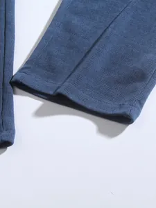 Close-up detail of blue corduroy trouser cuff showing ribbed fabric texture.