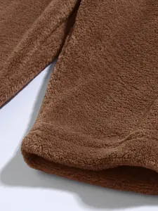 Close-up van de zachte bruine koraalvlies textuur op een casual heren hoodie detail.