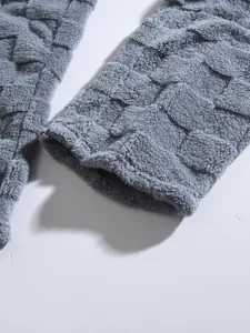 Close-up of grey checkerboard fleece fabric showing soft texture and detailed hem of men's set.