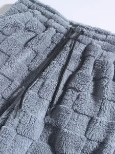 Detail view of grey plush checkerboard textured trousers showing waistband and black drawstring