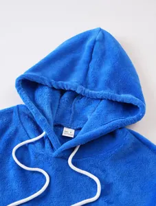 Detailopname van blauwe koraalvlies hoodie met zachte textuur en neklabel details.