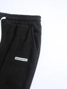 Detail of black corduroy texture and woven label on high-street style men's pants