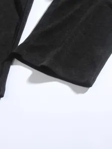 Detail view of the soft black corduroy fabric texture and hem of men's casual pants